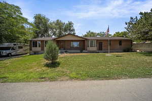 Ranch-style house featuring brick siding and a front yard