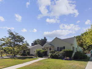 View of front of property with a front yard and roof with shingles