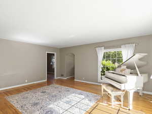 Living area with arched walkways and wood finished floors