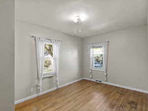 Empty room with healthy amount of natural light and light wood-style flooring