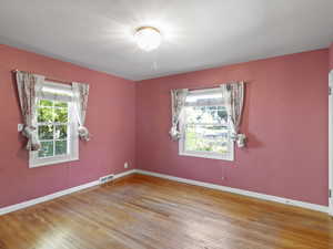 Empty room with wood-type flooring and baseboards