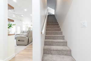 Staircase with recessed lighting, wood finished floors, and ceiling fan