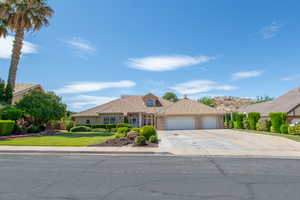 View of front of house featuring an attached garage, concrete driveway, brick siding, and a front yard