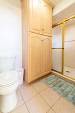 Bathroom with a stall shower and tile patterned floors