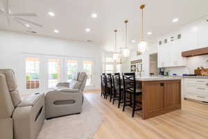 Kitchen featuring open floor plan, light wood-style floors, a spacious island, light countertops, and recessed lighting