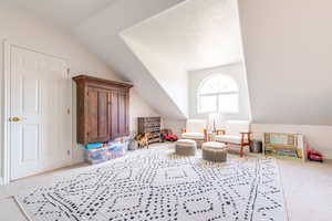 Sitting room featuring carpet flooring and vaulted ceiling