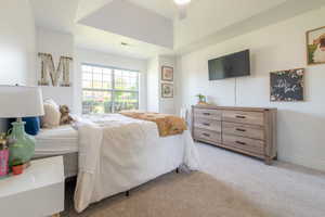 Bedroom with light colored carpet and a ceiling fan