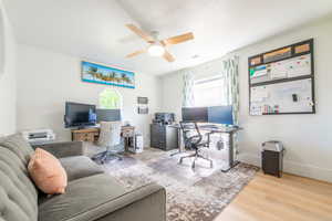 Office area with healthy amount of natural light, ceiling fan, and wood finished floors