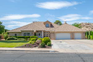 View of front of home featuring a front lawn, a garage, driveway, and brick siding