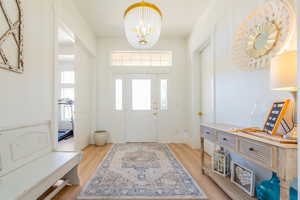 Entrance foyer with a chandelier and light wood-type flooring