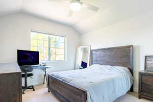 Carpeted bedroom featuring lofted ceiling and ceiling fan