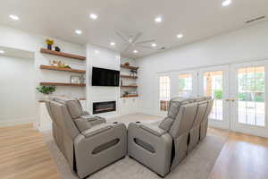 Living room with light wood-style flooring, ceiling fan, french doors, recessed lighting, and a fireplace