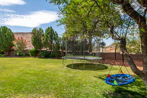 Fenced backyard with a trampoline