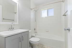 Bathroom featuring vanity, shower / bathtub combination, and tile patterned floors