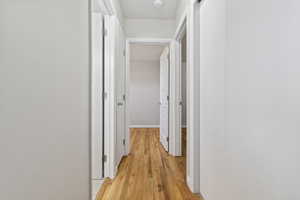 Corridor featuring light wood finished floors and baseboards