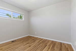 Empty room featuring baseboards and light wood-type flooring