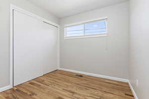 Unfurnished bedroom with light wood finished floors and a closet