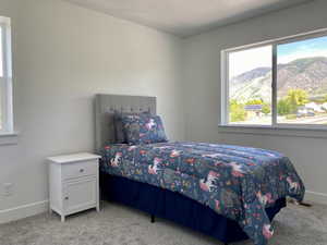 Bedroom with light colored carpet and a mountain view