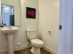 Half bath featuring baseboards and dark wood-style floors
