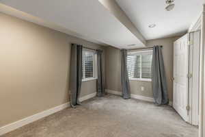 Unfurnished bedroom featuring light carpet and baseboards