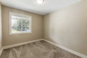 Carpeted empty room featuring baseboards and a textured ceiling