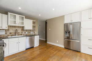 Kitchen with appliances with stainless steel finishes, recessed lighting, white cabinetry, and light wood-style floors