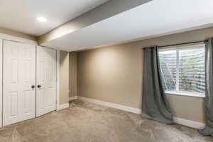 Unfurnished bedroom with light colored carpet, a closet, and recessed lighting