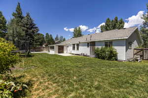 Rear view of house featuring a trampoline, a patio, a fenced backyard, and a shingled roof