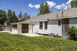 Rear view of property with a patio area and roof with shingles