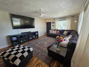Living area featuring wood finished floors, a ceiling fa.