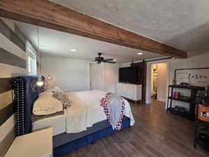 Bedroom featuring a barn door, wood finished floors, beam ceiling, recessed lighting, and a textured ceiling