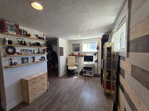 Office space featuring dark wood finished floors and a textured ceiling
