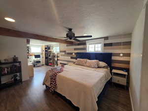 Bedroom with wood finished floors, wood walls, a textured ceiling, recessed lighting, and ceiling fan