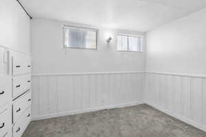 Carpeted empty room with a wainscoted wall