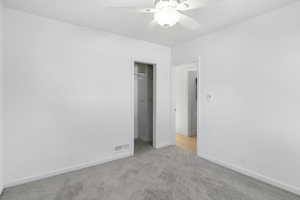 Unfurnished bedroom with carpet flooring, ceiling fan, and a closet