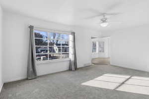 Carpeted spare room with ceiling fan