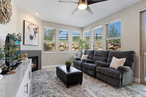 Living area featuring views, ceiling fan, wood finished floors, a tile fireplace, and recessed lighting