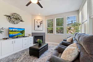 Living area with a ceiling fan, a fireplace, and recessed lighting