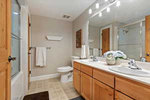 Bathroom featuring double vanity and baseboards