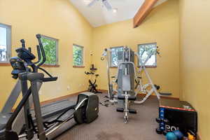 Workout area with lofted ceiling and baseboards