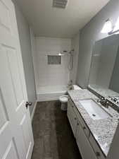 Bathroom with vanity, a textured ceiling, bathtub / shower combination, and tile patterned flooring