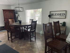 Dining room with ornamental molding and a chandelier