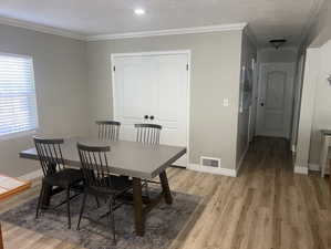 Dining area with light wood finished floors and ornamental molding