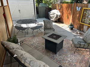 View of patio featuring a storage unit, a grill, and a fire pit