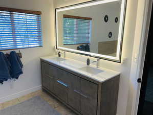 Full bathroom featuring double vanity and tile patterned floors
