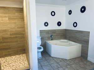 Bathroom featuring tile patterned floors, a garden tub, crown molding, and a tile shower