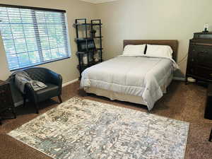 Carpeted bedroom with baseboards and ornamental molding