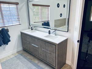 Bathroom featuring double vanity, healthy amount of natural light, and tile patterned flooring
