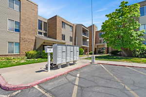 View of property's community with mail area and uncovered parking