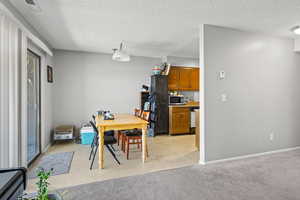 Dining room featuring a textured ceiling and light colored carpet